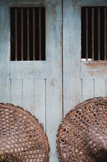 Vintage conical straw hats displayed on wall.