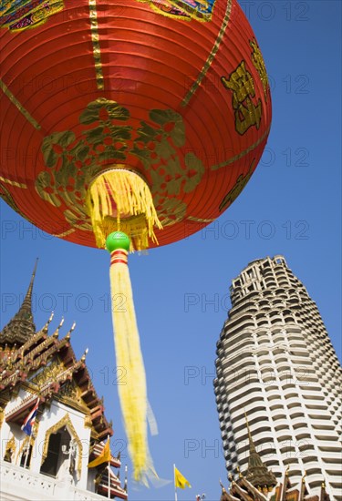 Wat Yannawa temple roof and unfinished apartment block from 1990s Asian financial crash with red lanterns at Chinese New Year.