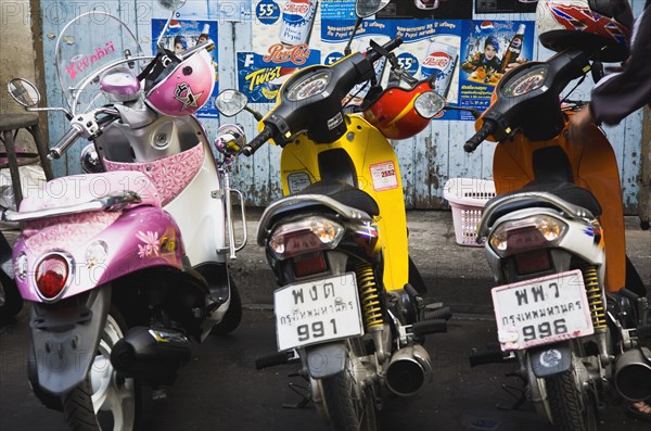 Brightly coloured motorcycle scooters and helmets.