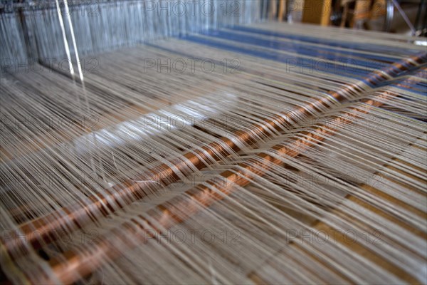 Close of an old traditional loom with cotton lined threads.