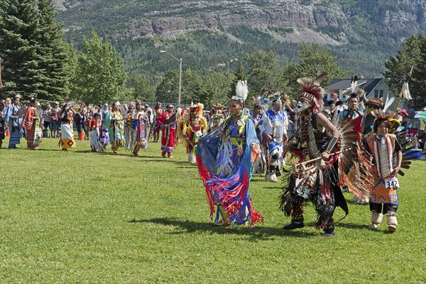 Grand Entry of dancers in full regalia at the Blackfoot Arts & Heritage Festival Pow Wow organized by Parks Canada and the Blackfoot Canadian Cultural Society at this UNESCO World Heritage Site Mount Vimy in the background