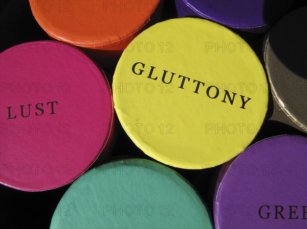 Colourful trinket boxes on a market displaying the words of the Seven Deadly Sins.