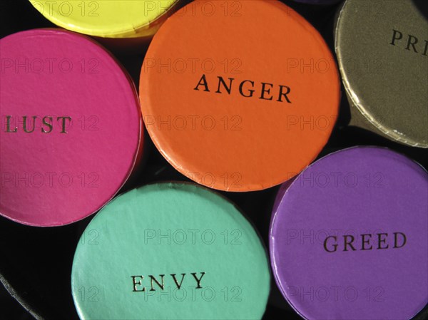 Colourful trinket boxes on a market displaying the words of the Seven Deadly Sins.