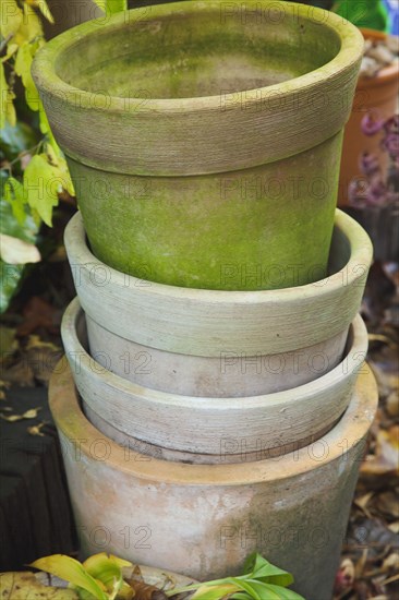 Clay flowerpots stacked in garden.