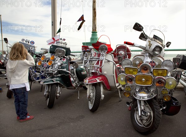 Elaborately decorated Mopeds on Madeira Drive during motorbike festival.