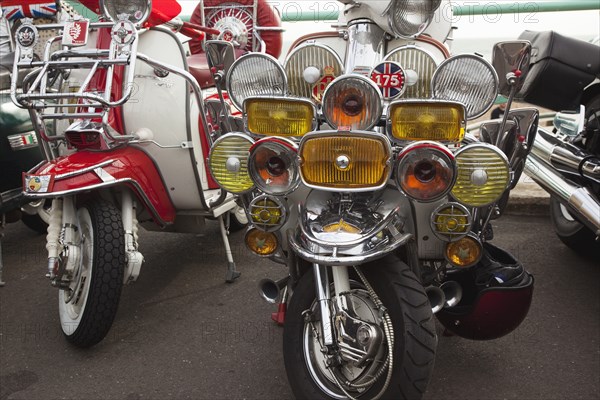 Elaborately decorated Mopeds on Madeira Drive during motorbike festival.