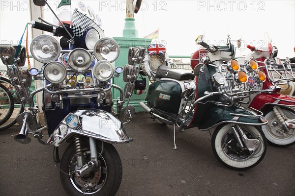 Elaborately decorated Mopeds on Madeira Drive during motorbike festival.