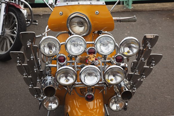 Elaborately decorated Mopeds on Madeira Drive during motorbike festival.