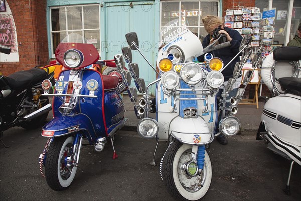 Elaborately decorated Mopeds on Madeira Drive during motorbike festival.