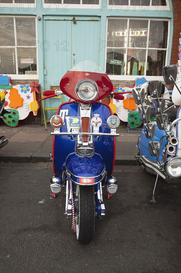 Elaborately decorated Mopeds on Madeira Drive during motorbike festival.