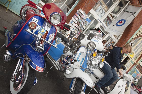 Elaborately decorated Mopeds on Madeira Drive during motorbike festival.