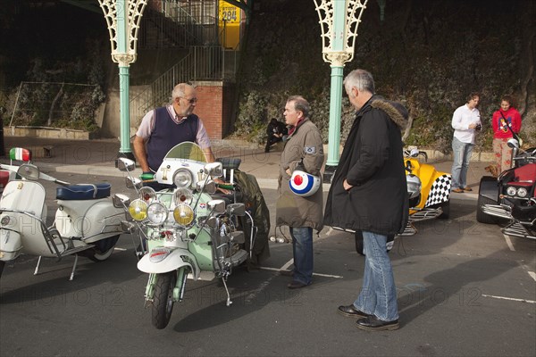 Elaborately decorated Mopeds on Madeira Drive during motorbike festival.