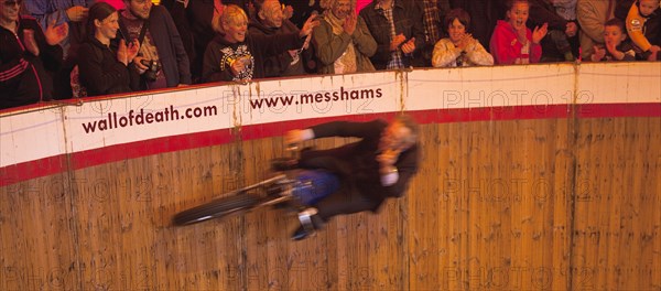 Wall of death motorcycle fairground attraction on Madeira Drive during motorbike festival.