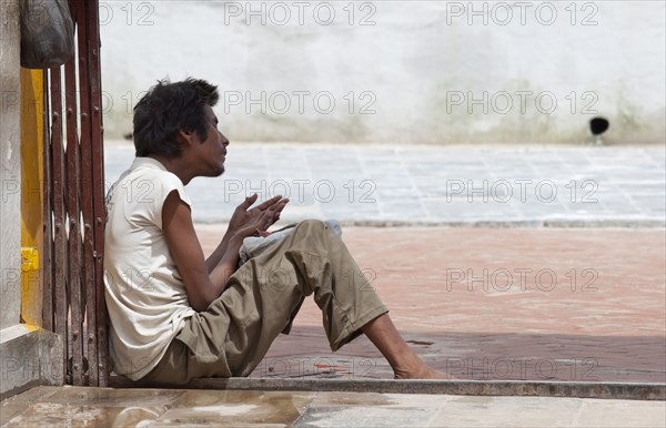 Sick man begs for alms near Swayambhunath Stupa.