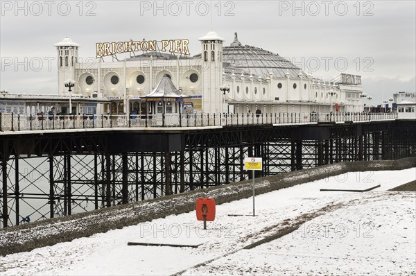Pier during winter with snow on the beach.