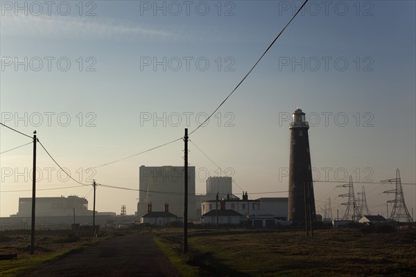Silhouetted Nuclear power station and lighthouse.