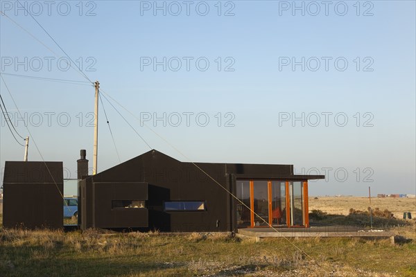 Old fishermans cottage covered in black rubberised weatherproofing.