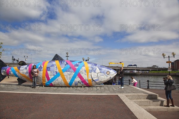 Donegall Quay The Big Fish Sculpture by John Kindness. The scales of the fish are pieces of printed blue tiles with details of Belfasts history. The 10 metre long structure is situated beside the Lagan Weir opposite the old Custom House.