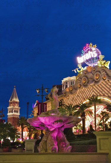 Harrahs and Venetian Hotel behind illuminated fountain.