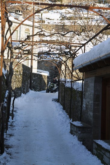 Little Papigko Village Narrow and frozen alley at the end of which a four weel drive bugy is noticeable