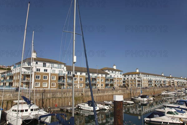 View over boats moored in the Marina with apartment buildings behind.