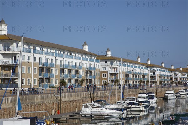 View over boats moored in the Marina with apartment buildings behind.