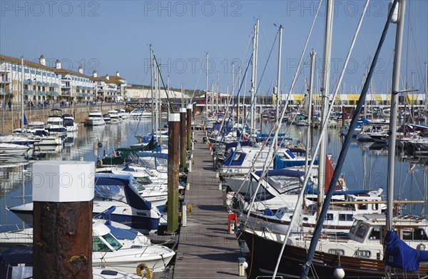 View over boats moored in the Marina with apartment buildings behind.