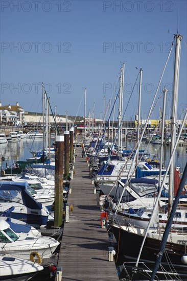 View over boats moored in the Marina with apartment buildings behind.