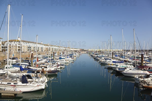 View over boats moored in the Marina with apartment buildings behind.