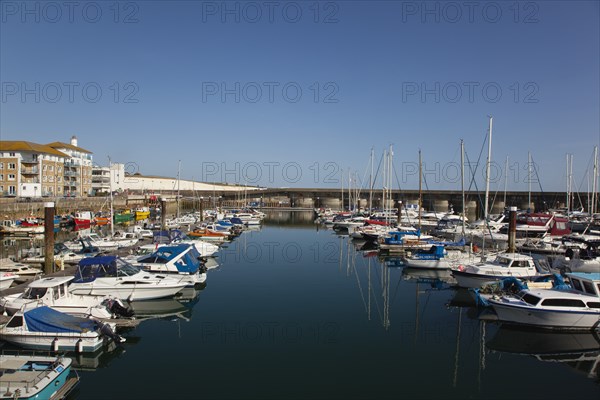 View over boats moored in the Marina with apartment buildings behind.