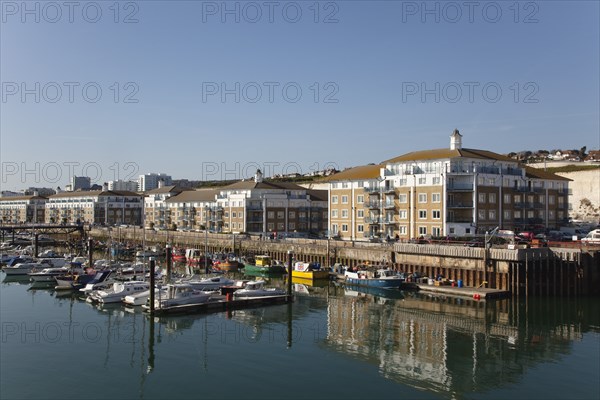 View over boats moored in the Marina with apartment buildings behind.