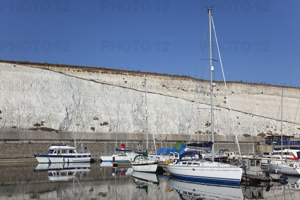 Boats moored in the Marina with chalk cliffs behind.