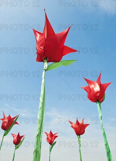 Sculture Plastic Tulips against a blue sky.