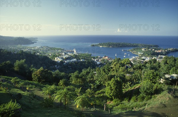 West Indies, Jamaica, Port Antonio, View over tree covered hillside towards waterside town and harbour. Photo : David Cumming