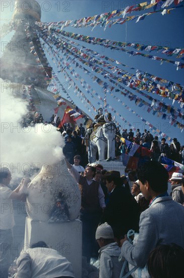 Nepal, Boudhanath, Burning pine bough incense during New Year or Los Har. Photo : Jon Burbank