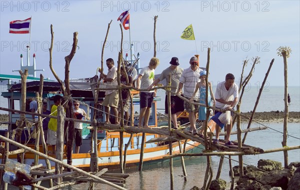 Thailand, Koh Samui, Thong Krutt fishing village. Tourists disembarking from a wooden boat after a fishing day trip. Photo : Derek Cattani