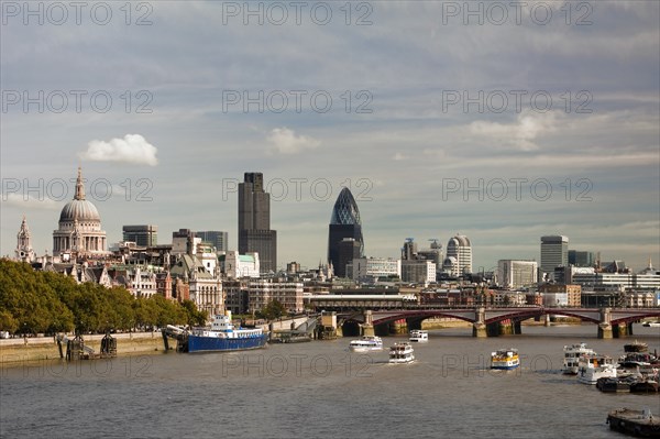 England, London, Skyline with view across the Thames towards Blackfriars Bridge from left to right St Pauls Cathedral Tower 42 and Swiss Re Tower. Boats on the water in the foreground. Photo : Derek Cattani