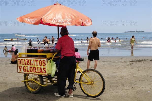 Mexico, Veracruz, Snack seller on Playa Villa del Mar with people on beach and in sea. Photo : Nick Bonetti