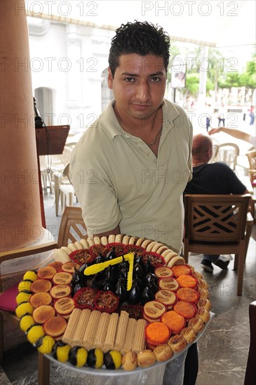 Mexico, Veracruz, Sweet seller in the Zocalo displaying large plate with variety of sweets. Photo : Nick Bonetti