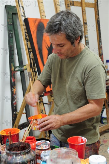 Mexico, Bajio, San Miguel de Allende, Artist Juan Ezcurdia in his studio mixing paint. Photo : Nick Bonetti