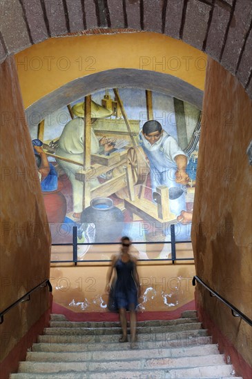 Mexico, Bajio, San Miguel de Allende, Bellas Artes Mural by Pedro Martinez dated 1940 with woman descending flight of stairs in foreground. Photo : Nick Bonetti