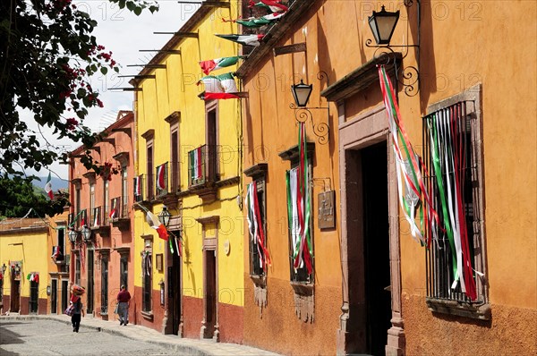 Mexico, Bajio, San Miguel de Allende, Independence Day decorations adorn colonial street lined with brightly painted buildings. Photo : Nick Bonetti