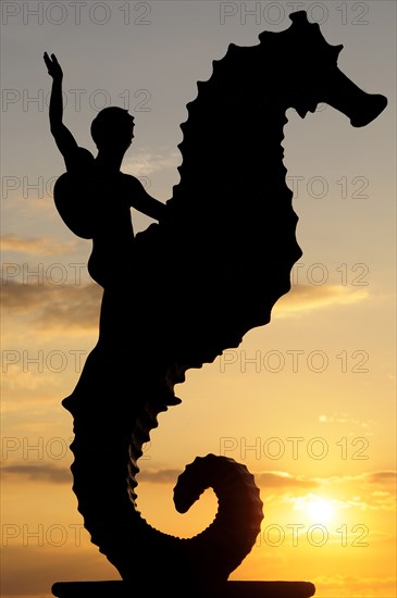 Mexico, Jalisco, Puerto Vallarta, Caballeo del Mar sculpture of boy riding a seahorse by Rafel Zamarripa silhouetted on the Malecon at sunset. Photo : Nick Bonetti