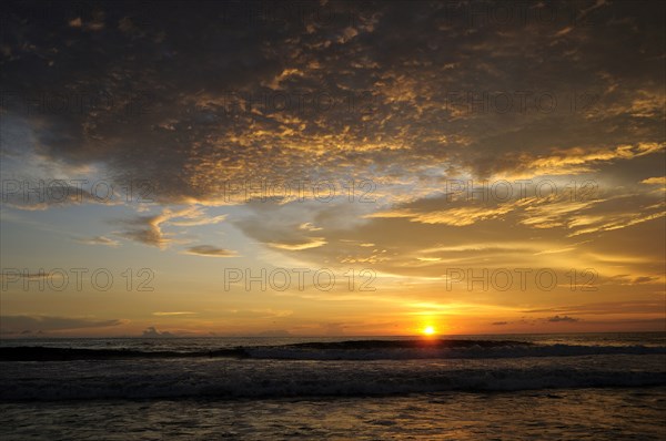 Mexico, Oaxaca, Puerto Escondido, Puerto Escondido Sunset over Playa Zicatela with waves breaking on shore. Photo : Nick Bonetti