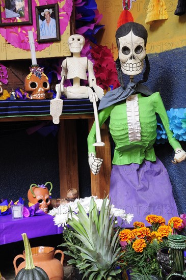 Mexico, Michoacan, Patzcuaro, Dia de los Muertos Day of the Dead altar with skeleton figures flowers and colourful paper decorations. Photo : Nick Bonetti