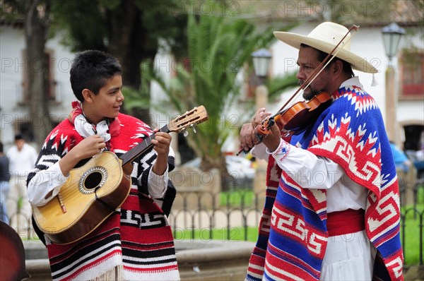 Mexico, Michoacan, Patzcuaro, Musicians playing violin and guitar during performance of Danza de los Viejitos or Dance of the Little Old Men in Plaza Vasco de Quiroga. Photo : Nick Bonetti