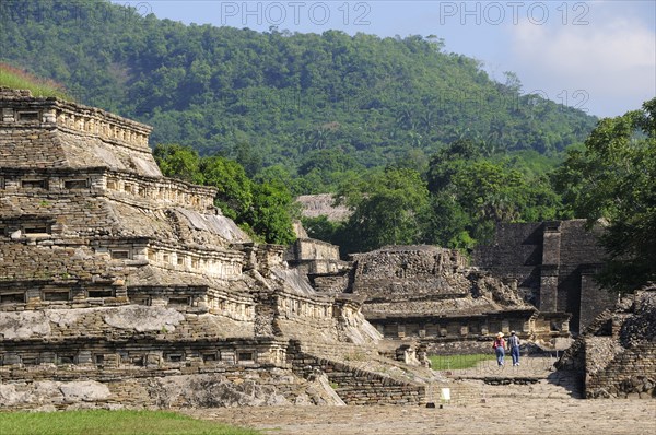 Mexico, Veracruz, Papantla, El Tajin archaeological site View of Tajin Viejo site with hills behind tourist couple in middle foreground. Photo : Nick Bonetti