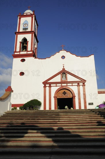 Mexico, Veracruz, Papantla, Cathedral de la Asuncion white and red painted exterior facade and bell tower with flight of steps to entrance. Photo : Nick Bonetti