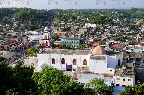 Mexico, Veracruz, Papantla, Views over Cathedral Zocalo and surrounding buildings set amongst trees. Photo : Nick Bonetti