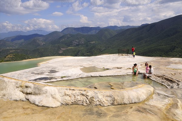 Mexico, Oaxaca, Hierve el Agua, Tourists beside limestone pools and looking out over surrounding countryside. Photo : Nick Bonetti